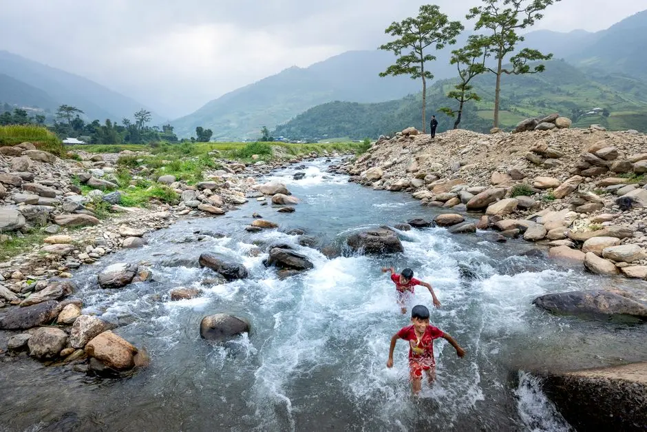 Keluarga bermain di sungai jernih di tengah hutan